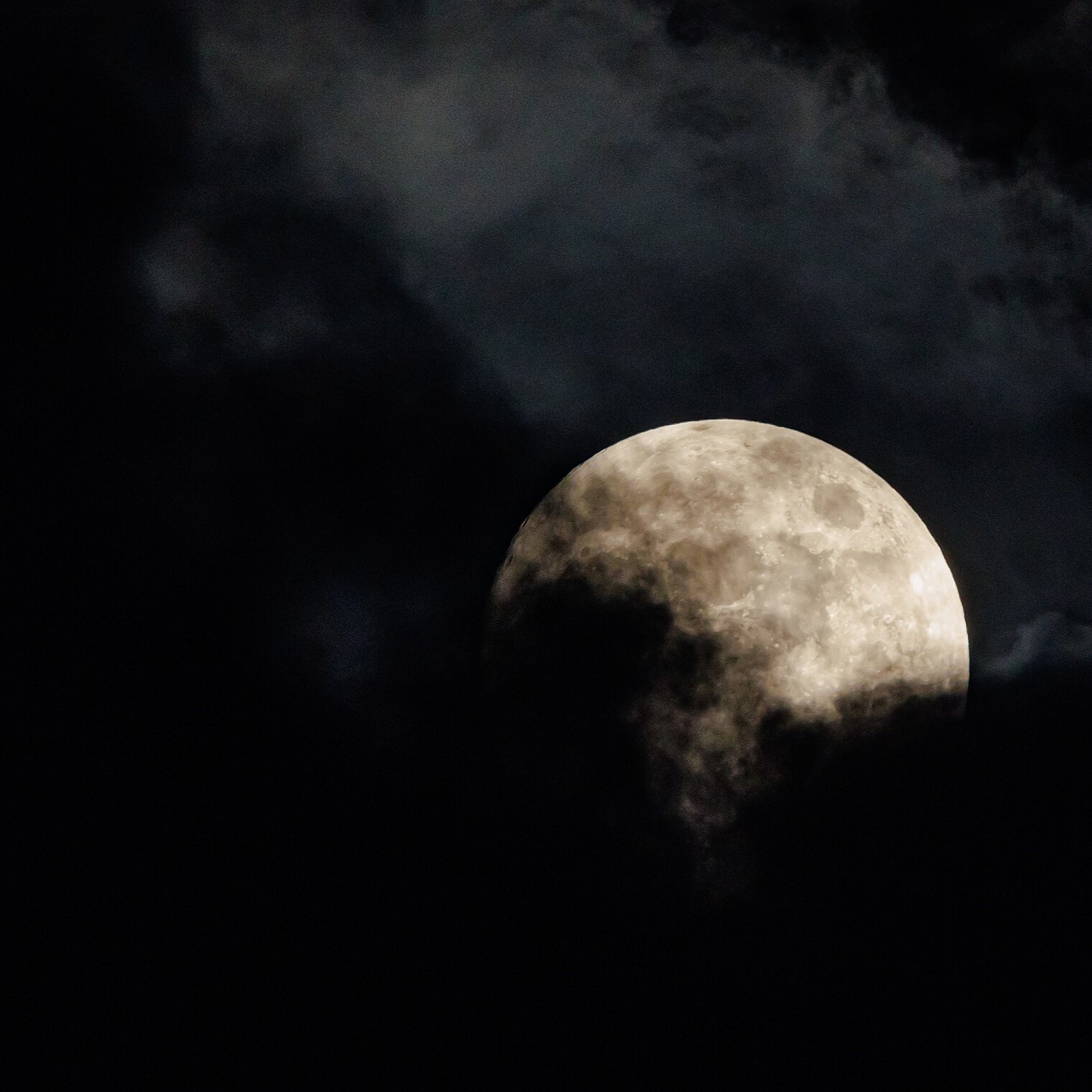 Full moon behind clouds