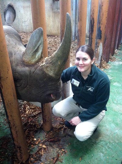 Cindy Wagner kneeling next to a black rhino at Potter Park Zoo