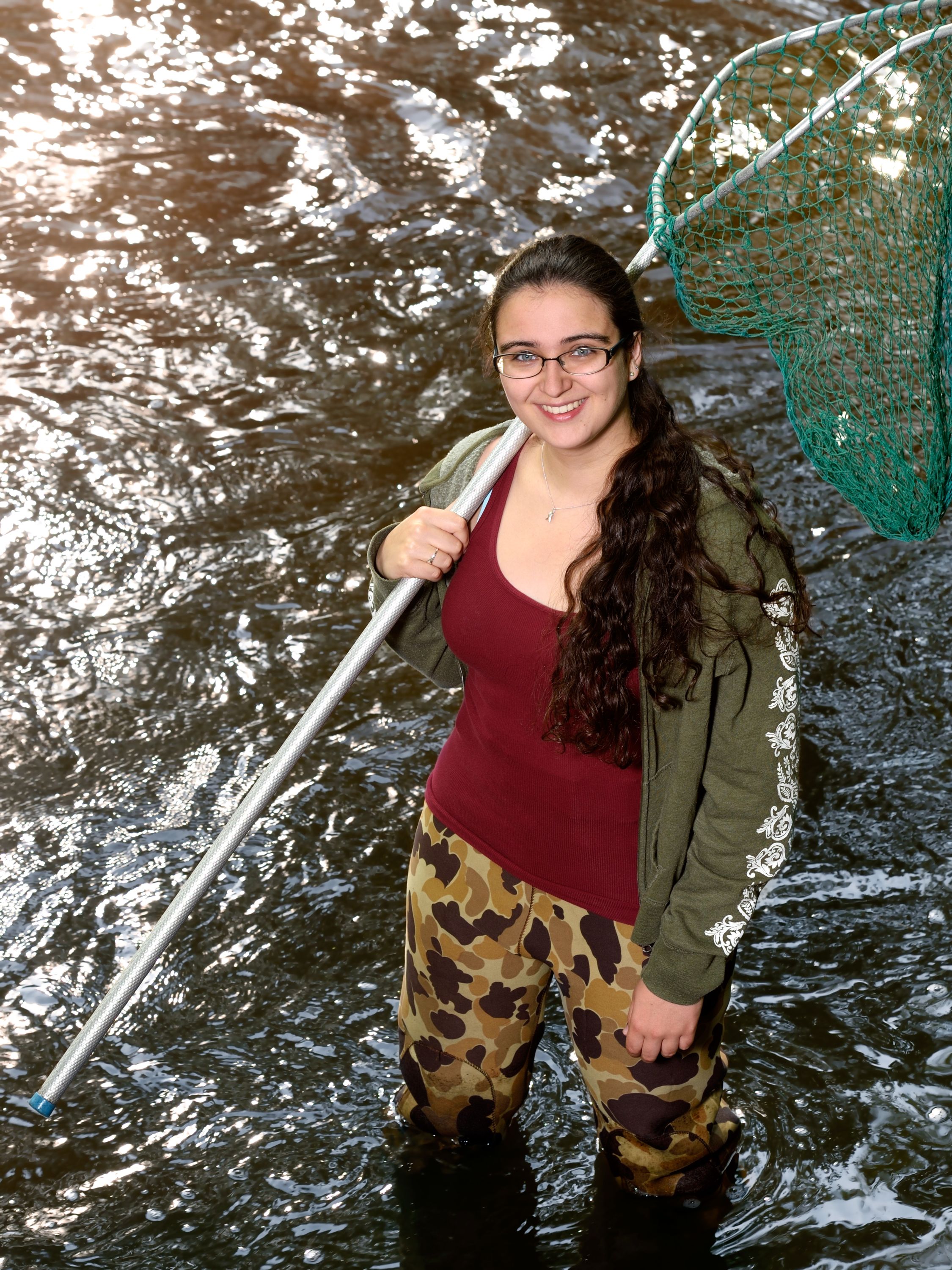 Clara Lepard standing in a body of water holding a net