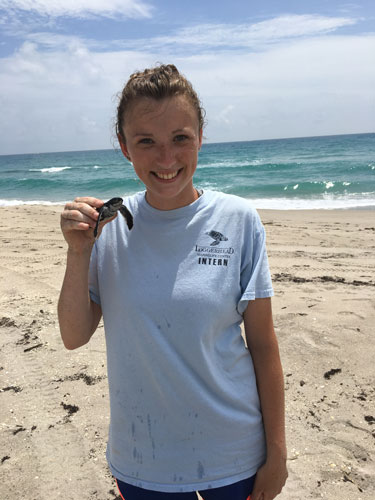 Heather Seaman holding a young sea turtle.