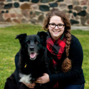 Amber Leuenberger crouching next to her dog outdoors
