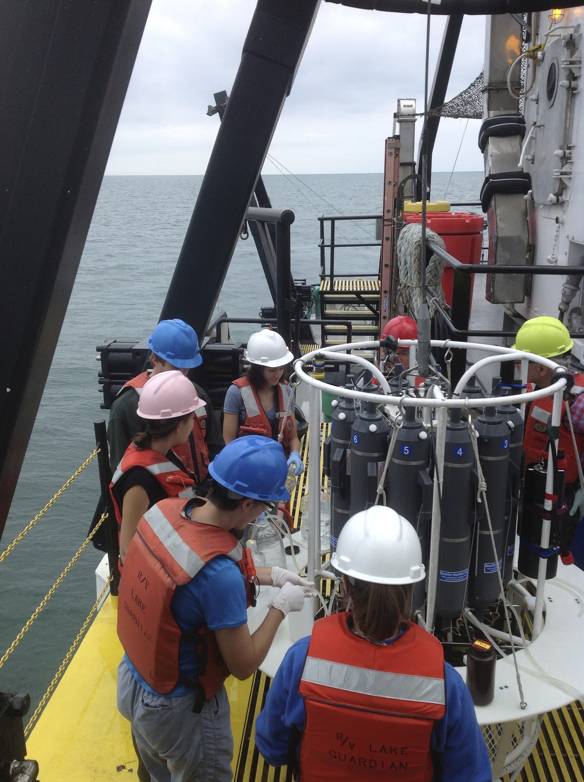 researchers on a boat collecting samples.