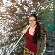Clara Lepard standing in a body of water holding a net