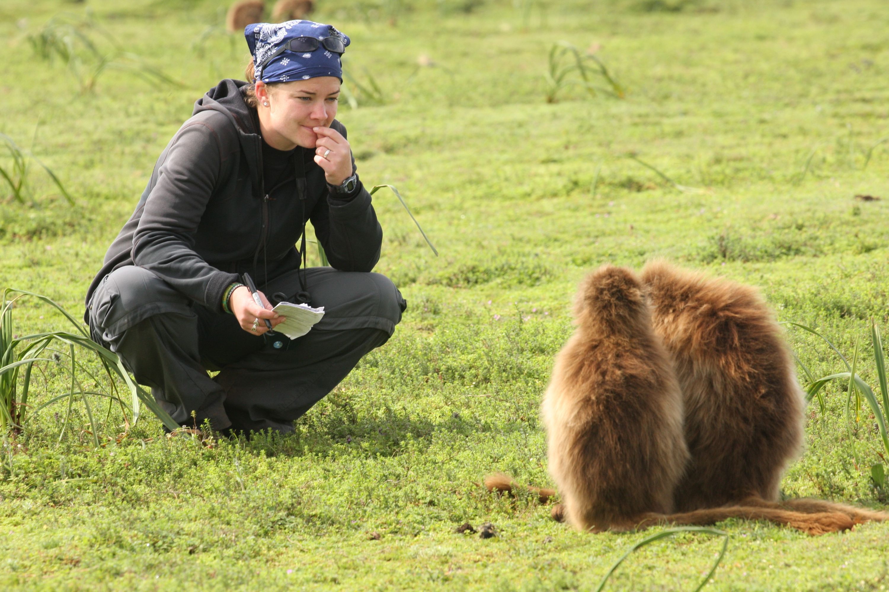 Eila crouched observing primates in the wild