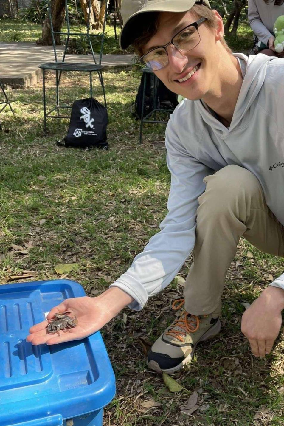Man in grey shirt holds scorpion in outstretched hand